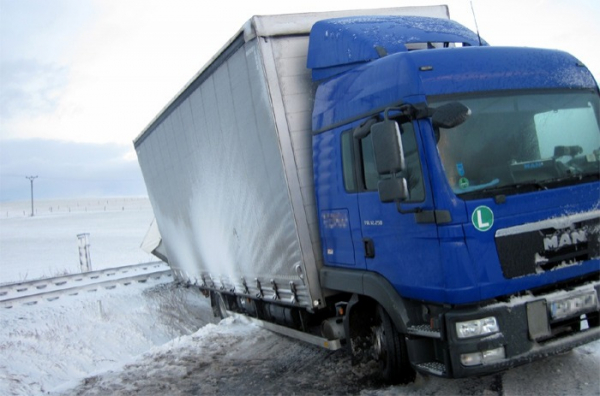 Převrácený nákladní přívěs zablokoval silniční i železniční dopravu