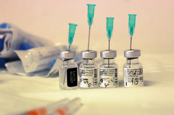 Ruce jednoho lékárníka připraví denně až 700 očkovacích dávek proti covid 19 